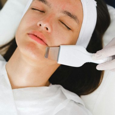 Beautician doing facial treatment procedure for patient