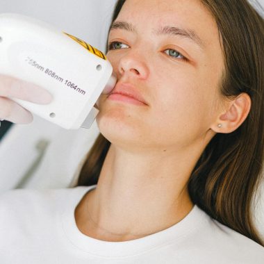 Calm woman client lying in medical room during visit to cosmetologist on low level laser therapy