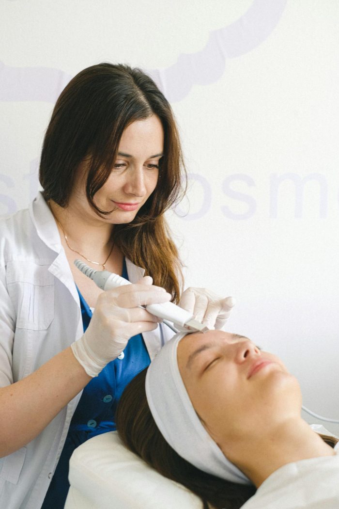 Cosmetologist doing facial treatment in beauty salon