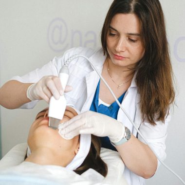 Cosmetologist doing ultrasonic face cleaning to client